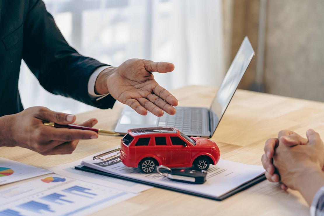 predajca aut podpisuje zmluvu so zákazníkom
